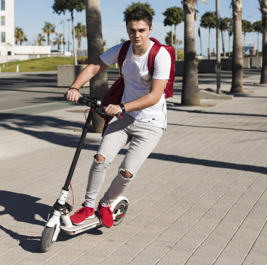 Persona circulando en scooter por una vía urbana