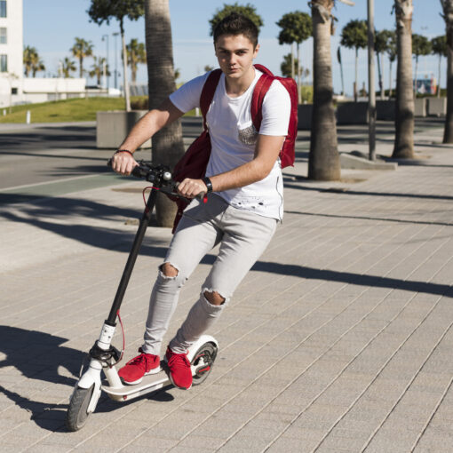Persona circulando en scooter por una vía urbana